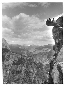 A.E. McConnell and daughter sitting on the precarious Glacier Point in Yosemite National Park, 1901