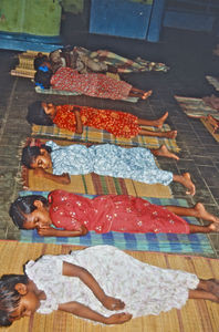 08.- Mission for børn i Indien. Diasserie 1990, "Da jeg blev velsignet af en elefant". Når pigerne på Siloam skal sove, så ruller de bare deres bastmåtter ud på gulvet og lægger sig til at sove under de store propeller i loftet. Det er alt for varmt til at have dyne, så det bruger de slet ikke