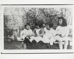 Four girls on a park bench