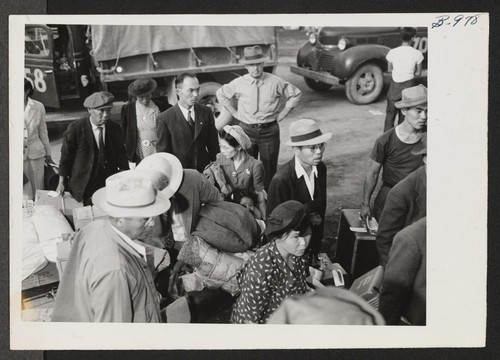 A group of the 254 evacuees transferred from the Minidoka Relocation Center to the Tule Lake Center boards the train at Hunt siding after riding the five miles from the center in trucks. Hunt, Idaho