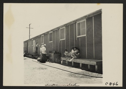 This is the type of barrack building in the relocation center. Each contains four rooms, to house four family groups. Each has it's own outside entrance, two at the side and one at each end. There are thirty-six blocks of barracks. Photographer: Lange, Dorothea Manzanar, California
