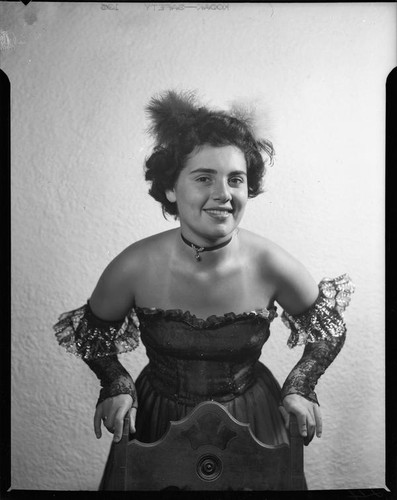 Young woman in Spanish-style costume leaning on chair, 1951