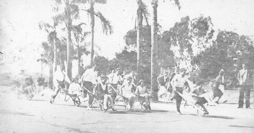 [People participating in a wheelbarrow race]