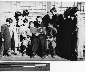 Fr. Escalante reading to children in Chiao Tow, Manchuria, China, 1936