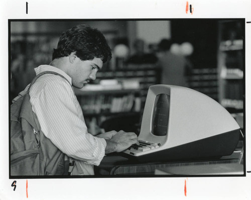 Student using computer in Payson Library, early 1980s