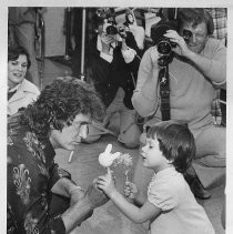 Michael Landon, the actor, at the Easter Seal Society Rehabilitation Center, in Sacramento to promote Easter Seals Telethon, with toddler Tara Funk