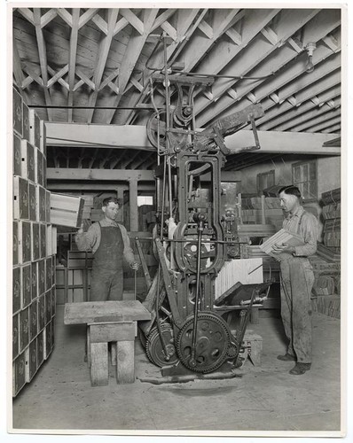 Workers using a machine to make boxes