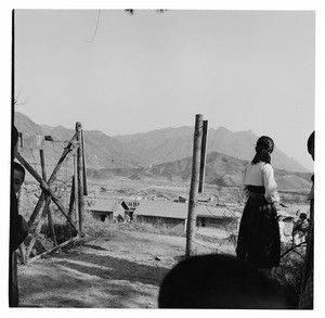 Woman by open gate overlooking a town in South Korea, 1956-59
