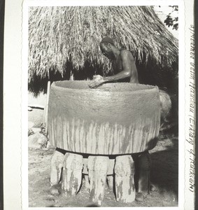 An Mbembe man building his granary