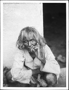 Old Hopi Indian man outside smoking a cigarette, ca.1900