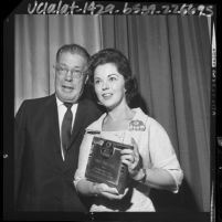 Shirley Temple Black posing with award she received from the California Teachers Association, 1964
