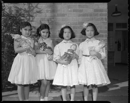 Little girls holding Christmas dolls