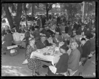 Attendees of the annual Iowa Picnic in Lincoln Park sit at picnic tables, Los Angeles, 1936
