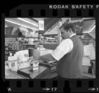 Ralph's Supermarket cashier, Mike Moore, demonstrating barcode scanner in Los Angeles, Calif., 1980