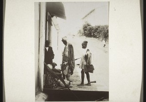 A trader with his servant in front of the Basel Mission Trading Company store