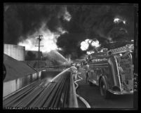 Fire fighters battling oil tank fire at Union Oil refinery in Wilmington, Calif., 1951