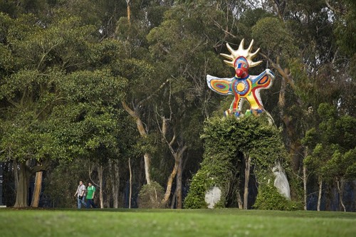 Sun God: general view of sculpture with vine covered arch and eucalyptus grove in background