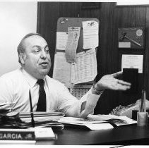 Frank Garcia Jr. Realtor. Caption reads, "Frank Garcia in his office; earlier he had vacuumed the carpet."
