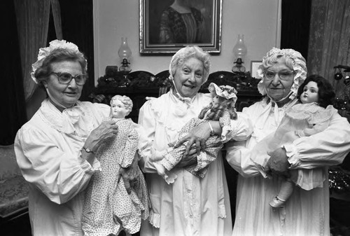Women in night caps holding porcelain dolls, Los Angeles, 1982