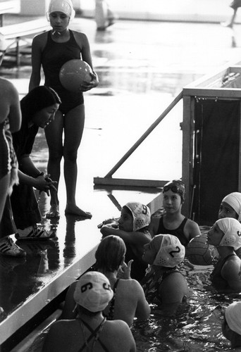 Women's water polo team discussing strategy at the Aquatorium