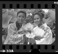 Sung Lee, Miss Korea, and Naomi Dguchi, Miss Nisei posing with lotus flowers at Lotus Festival in Los Angeles, 1975