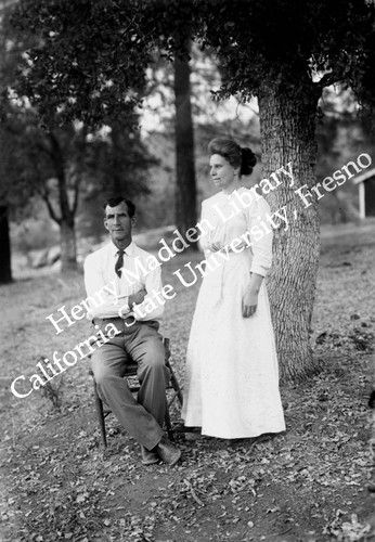 Couple posing next to oak tree