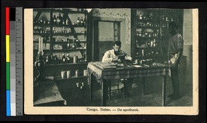 Apothecary looking into a microscope while a man looks on, Congo, ca.1920-1940