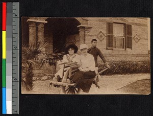 Miss Fillmore and Mrs. Garrett sitting in a barrow, Nantong, Jiangsu, China, 1916