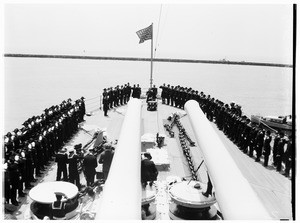 Officers saluting on the fantail of a battleship during a ceremony
