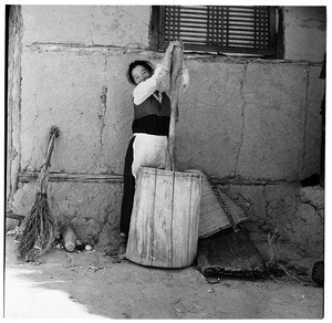 Woman working a wooden churn (?), Korea