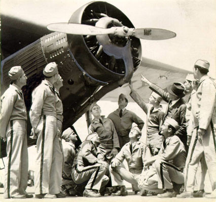 [Group of men posing with an airplane at Crissy Field]