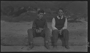 Two men at Willow Camp sitting on a log