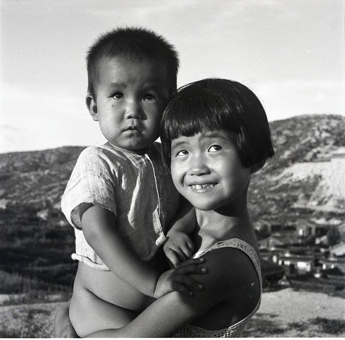Girl holding small boy in rural Korea