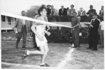 Runner crossing finish line, date unknown