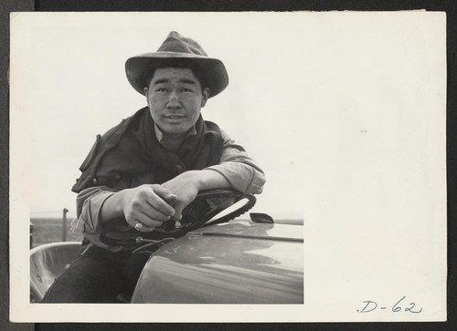 Tule Lake, Newell, Calif.--Jimmy Inahara, 24, farmer-evacuee from Stockton, California, operates a tractor on the farm at this War Relocation Authority center for evacuees of Japanese ancestry. Photographer: Stewart, Francis Newell, California