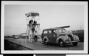 Department of Public Works surveyors scaling a small lookout tower, 1930-1939