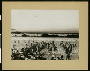 View of bathers on the beach in Long Beach with the pier in the background, ca.1910