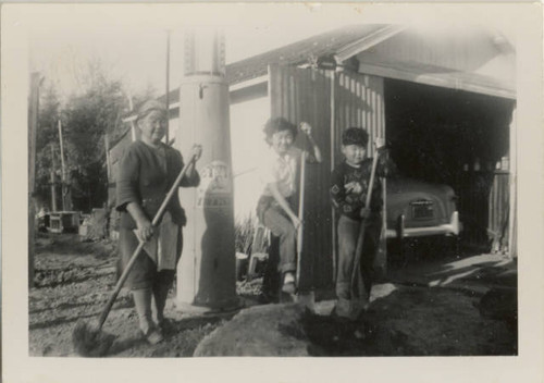Grandmother Tsukamoto, Marielle Tsukamoto, and Harold Ouchida, Jr. digging with shovels