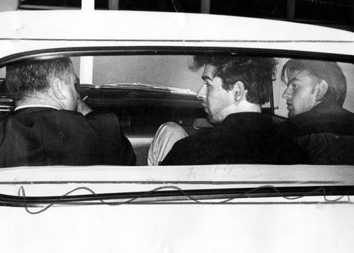Venice detective J. R. MacArthur, left, sits in car with kidnap-rape suspects transferred from North Hollywood