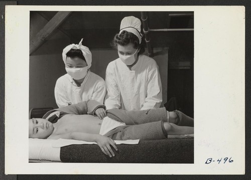 Registered Nurse, Mrs. Edythe Sasser, is assisted by Yoshiko Konatsu, Nurse's Aid, and Tomiko Kitasaki, Nurse's Aid, in the treatment