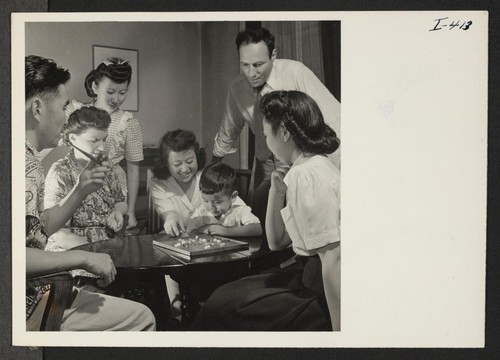 A game of Chinese checkers engages the attention of this group of temporary residents and others at the Greater New