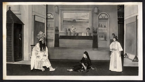 Man seated addresses a woman on the floor, a woman on the right looks on possibly at the Great Star Theatre /