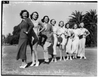 Line of actresses and models standing with their hands on their hips in a grassy field, Los Angeles, 1936