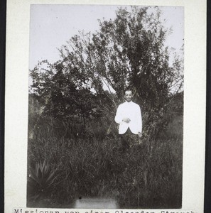 Missionar vor einem Oleander Strauch