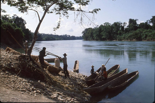 Guatemalan refugees work on canoes near a river, Puerto Rico, ca. 1983