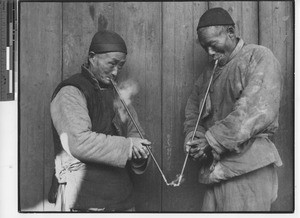 Two elderly men smoking pipes in China, 1936