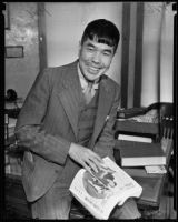 Japanese humorist Shiro Otsuji poses with a book or magazine, Los Angeles, 1935