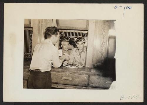 Manzanar, Calif.--Evacuee of Japanese ancestry receiving mail at Manzanar Post Office--a branch of the Los Angeles Post Office, more than 250 miles away. A two-cent stamp will send a letter by first-class mail from Manzanar to Los Angeles. Photographer: Albers, Clem Manzanar, California