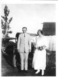 Florence R. Fickle and Robert Jerome Narron wedding picture taken in front of two vintage cars with a barn in the background, Feb 20, 1912