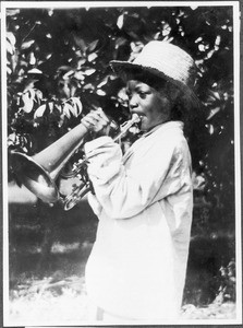 Boy playing the trombone, Tanzania, ca. 1927-1938